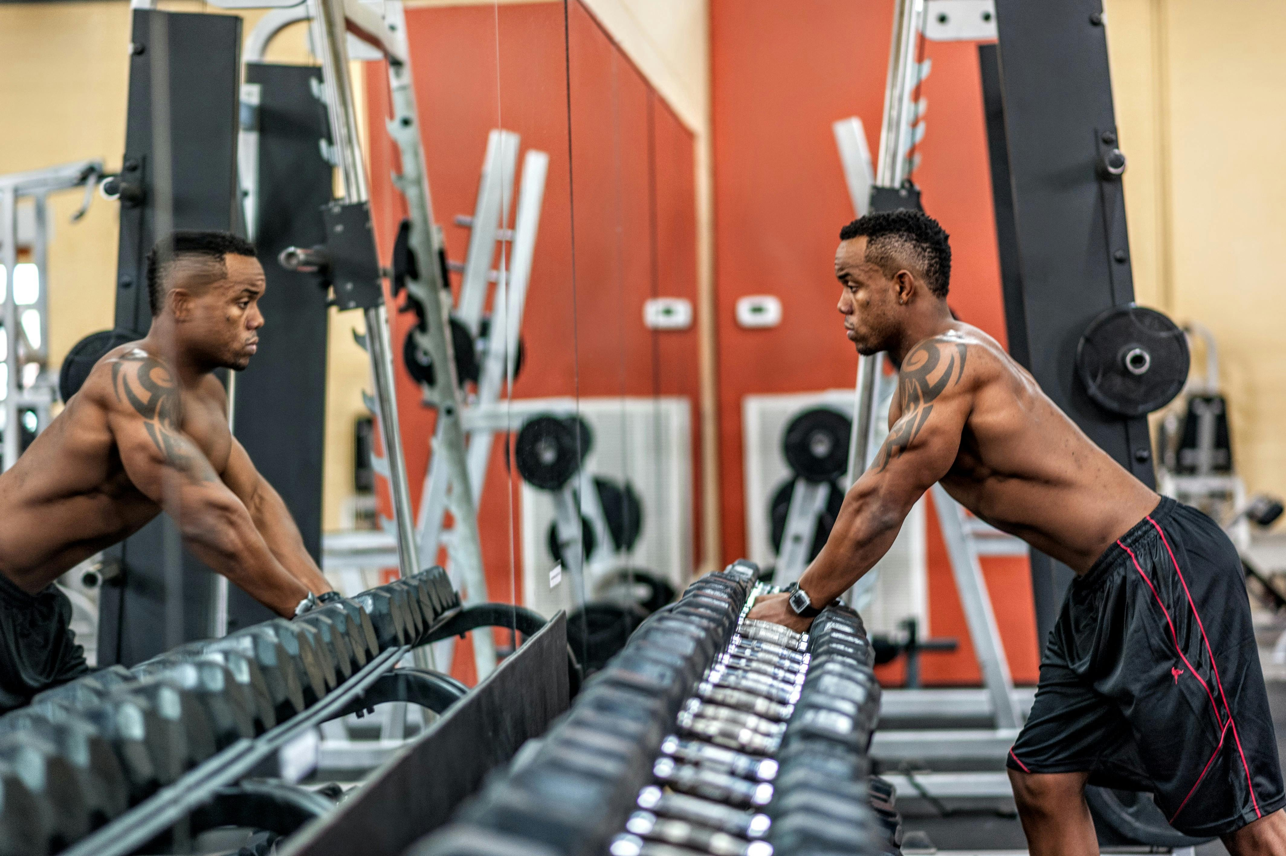 Man selecting dumbbells in gym demonstrating resistance training