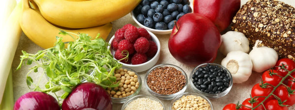 A vibrant flat lay of fiber rich foods for constipation like prunes, berries, broccoli, and lentils. 