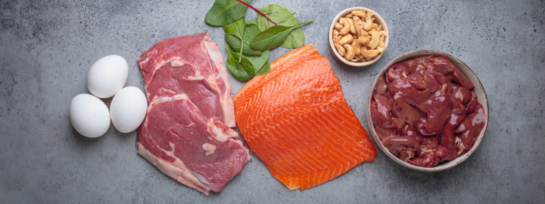 A selection of creatine food sources including red meat, fish, and chicken arranged on a plate. 