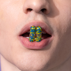 man eating multivitamin and omega capsule